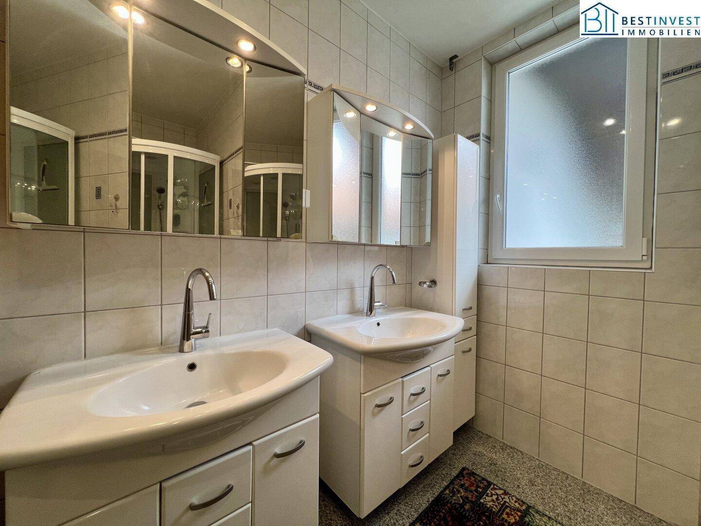 Badezimmer mit Doppelwaschbecken und Spiegelschränken, bietet ausreichend Platz für zwei Personen.