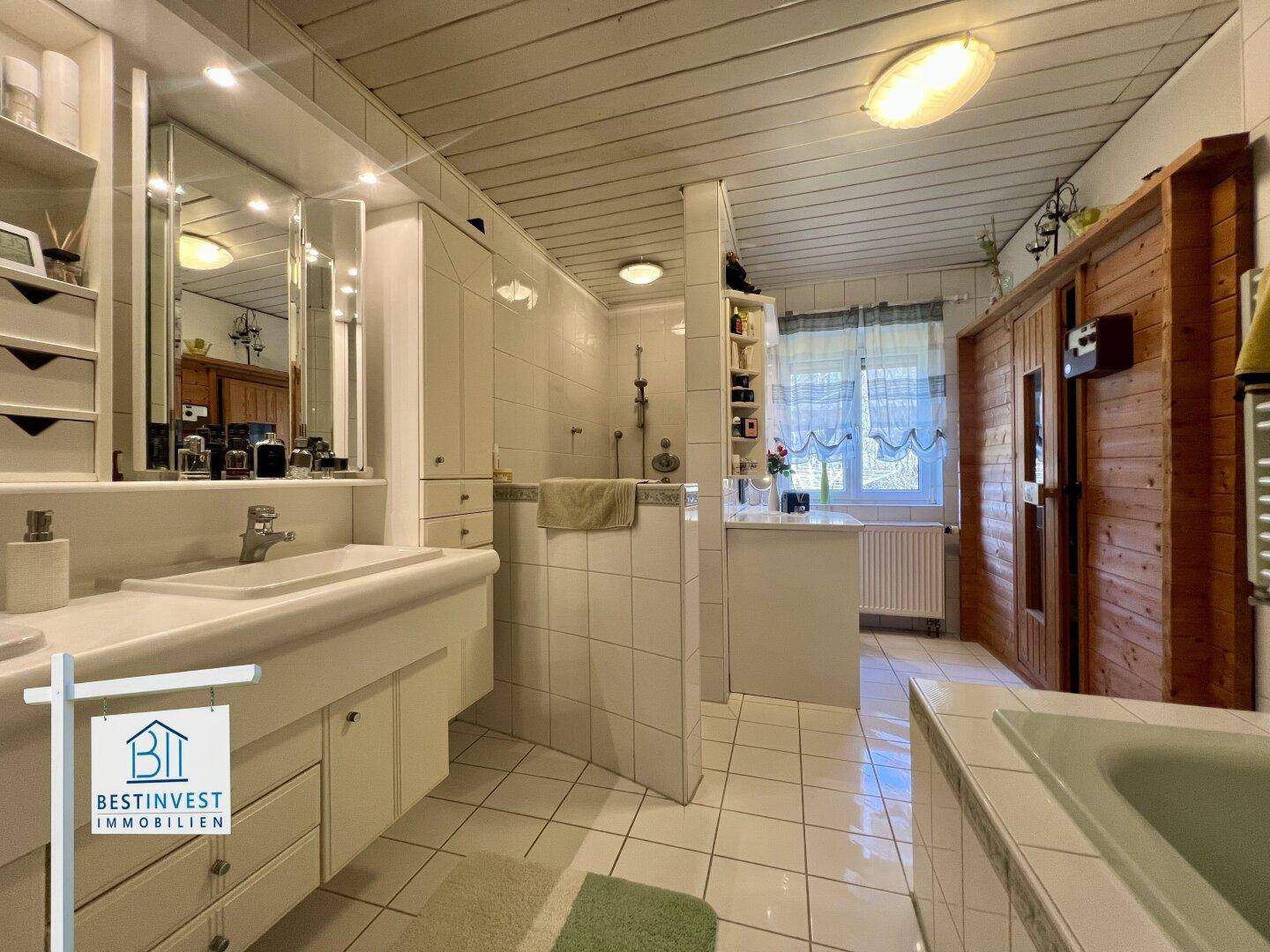 Geräumiges Badezimmer mit Sauna, Dusche, Doppelwaschbecken und Holzdecke.