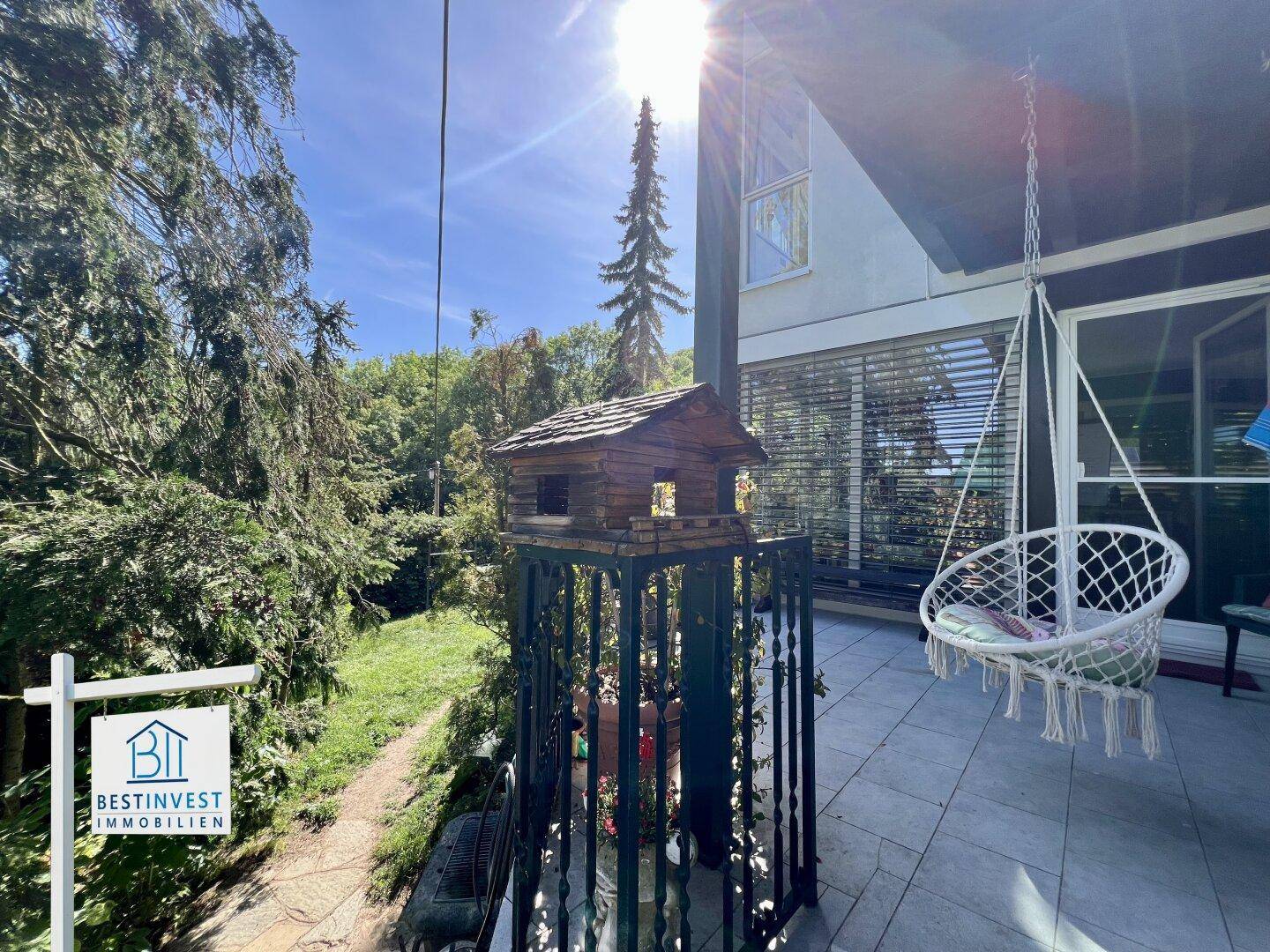 Gemütlicher Balkon mit Hängesessel und Blick ins Grüne, ideal für entspannte Stunden im Freien.