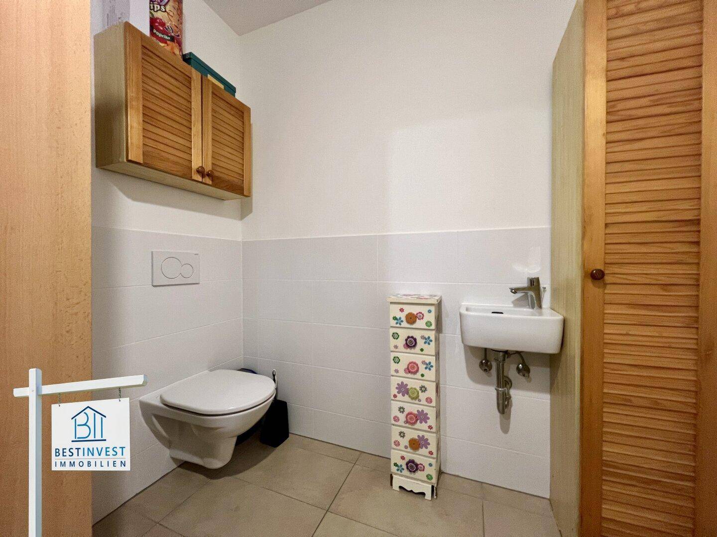 Separate Gästetoilette mit Wand-WC und kleinem Handwaschbecken.