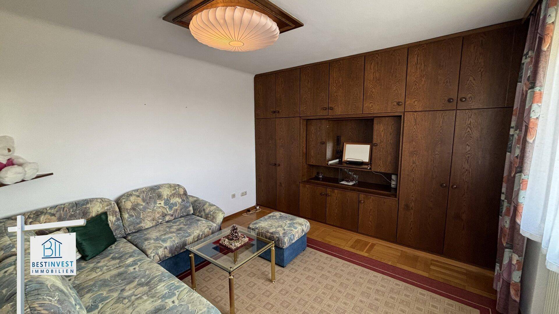 Wohnzimmer mit großem Einbauschrank aus Holz und gemütlicher Sitzecke.