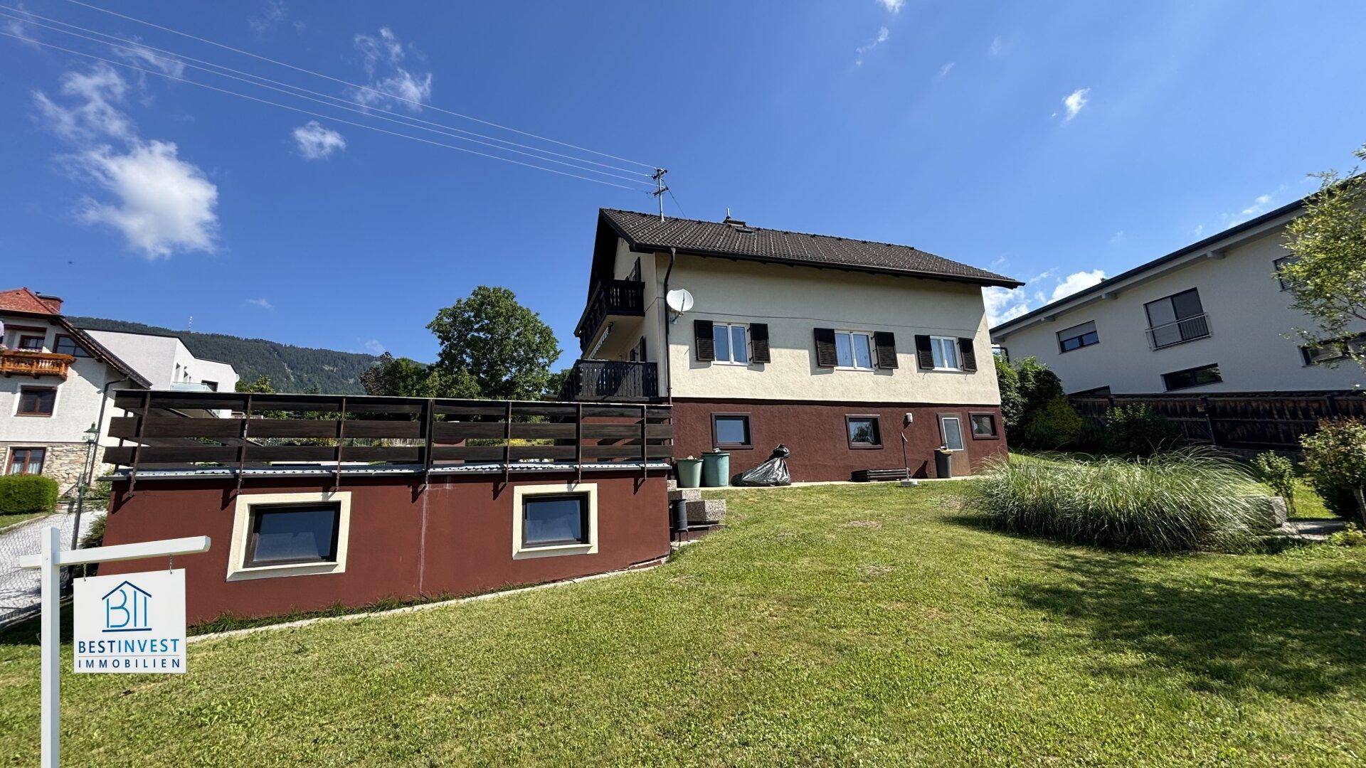 Seitenansicht des Hauses mit großem Gartenbereich und Blick auf die umliegende Natur.