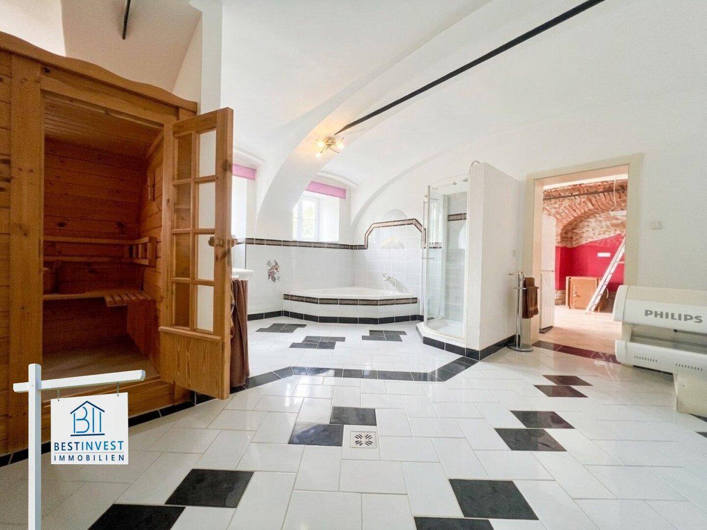 Großzügiges Badezimmer mit Sauna, Duschkabine, Eckbadewanne und markantem Fliesenboden.