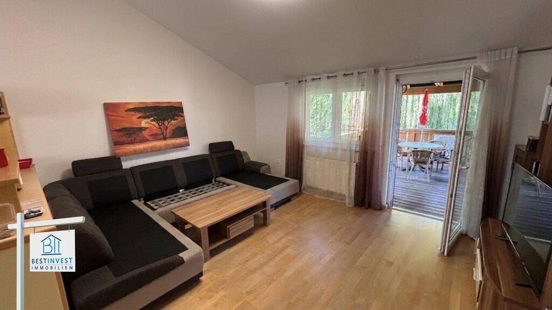 Gemütliches Wohnzimmer mit Ecksofa, Holzboden und direktem Zugang zum Außenbereich.