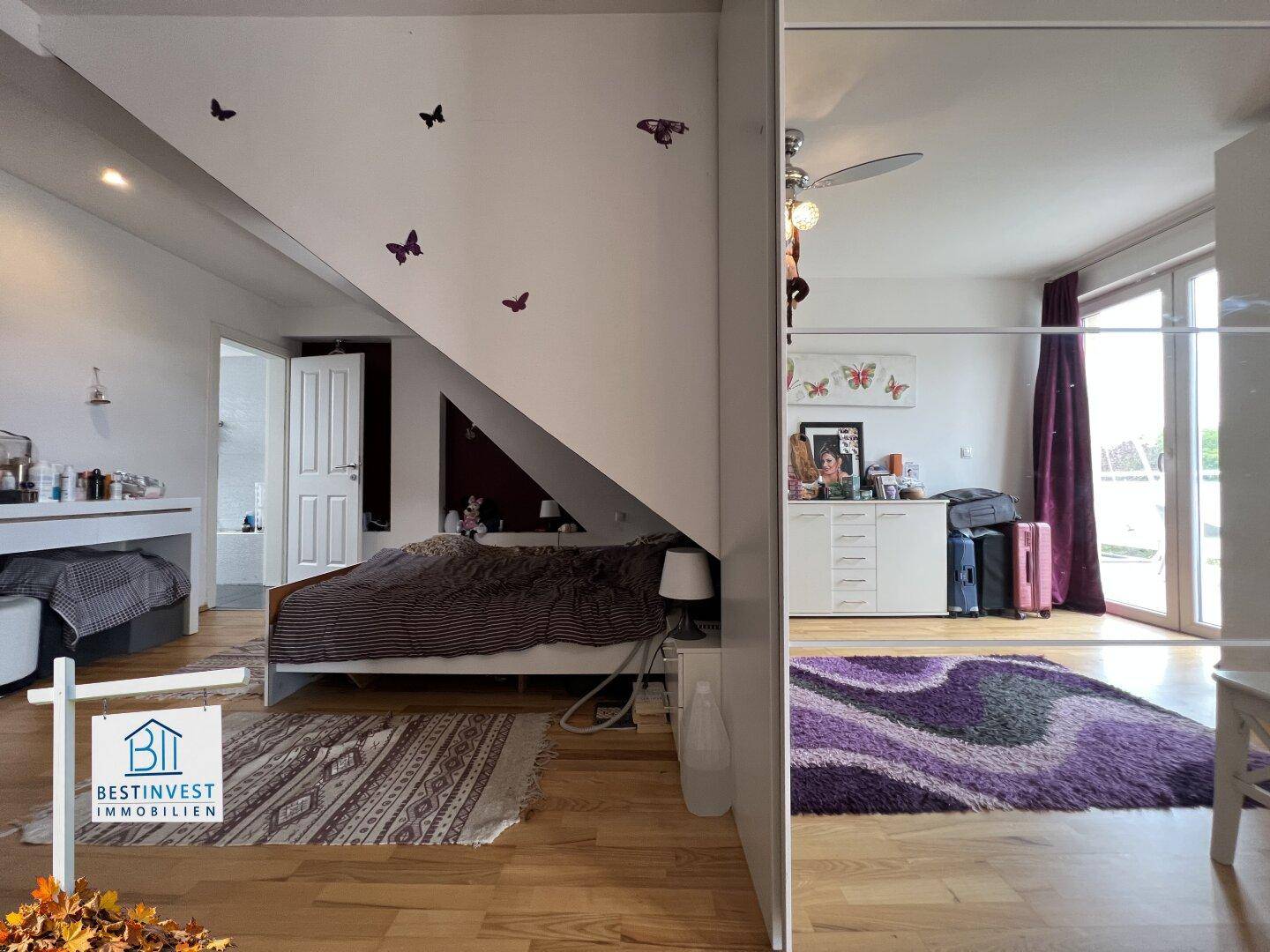 Gemütliches Schlafzimmer mit Dachschräge, Holzboden und großem Spiegelschrank.