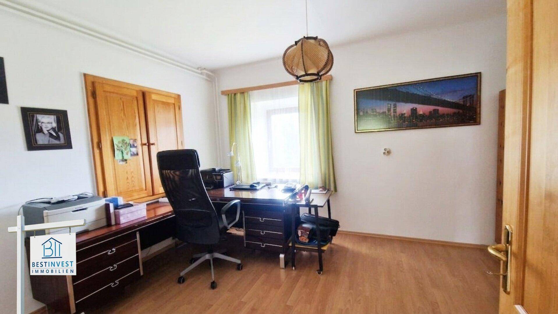 Helles Arbeitszimmer mit Holzfußboden und Fenster, ideal für Home-Office.