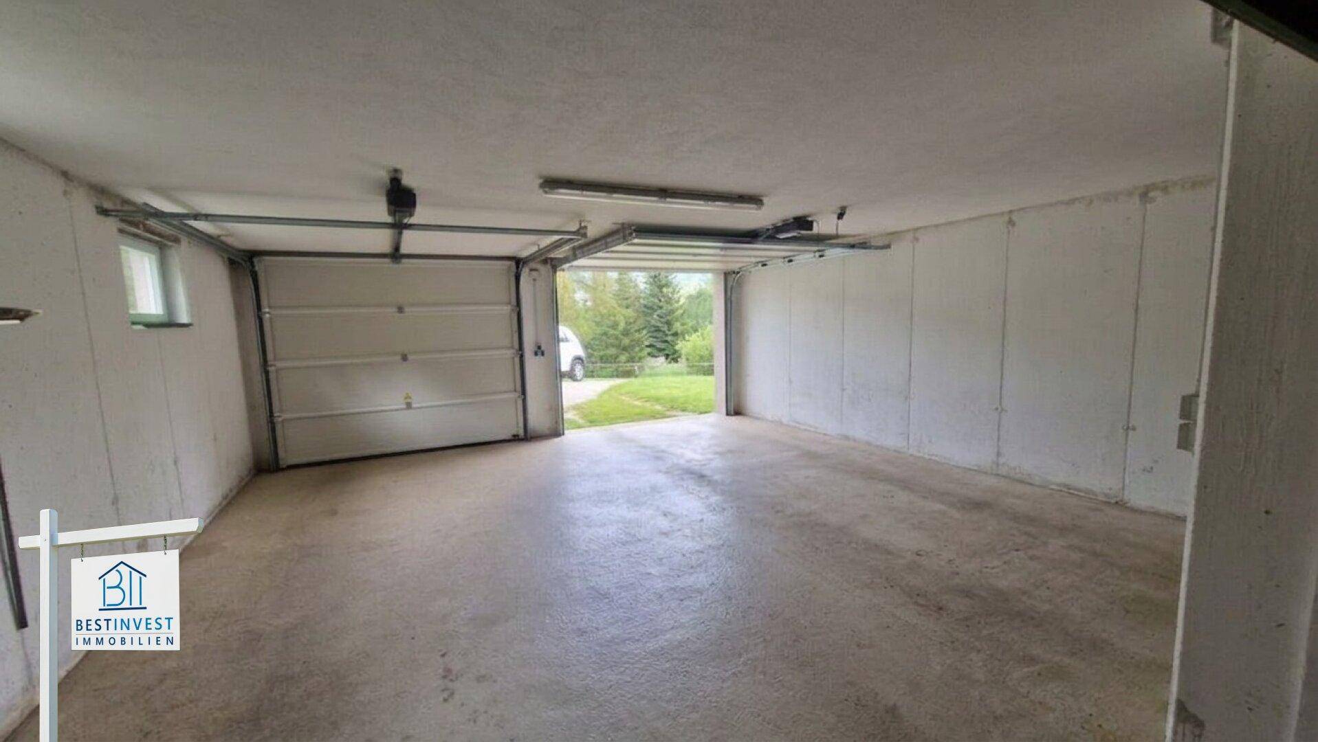 Geräumige Garage mit automatischem Tor und direktem Zugang zum Außenbereich.