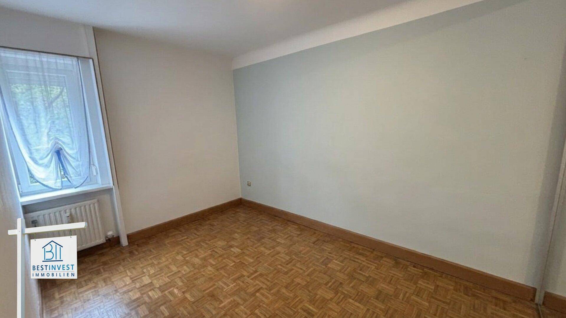 Unmöbliertes Zimmer mit Parkettboden und Fenster, bereit zur individuellen Gestaltung.