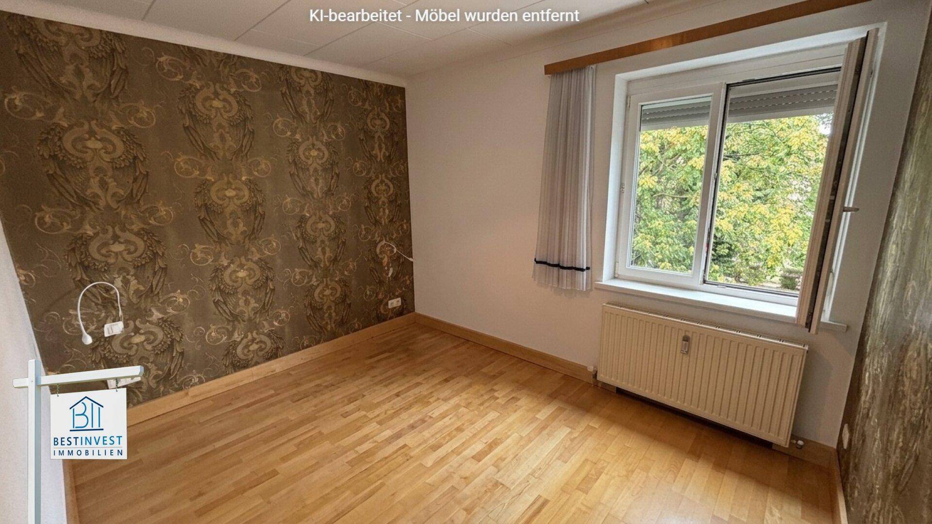 Unmöbliertes Schlafzimmer mit gemusterter Tapete, Parkettboden und Fenster mit Rollladen.