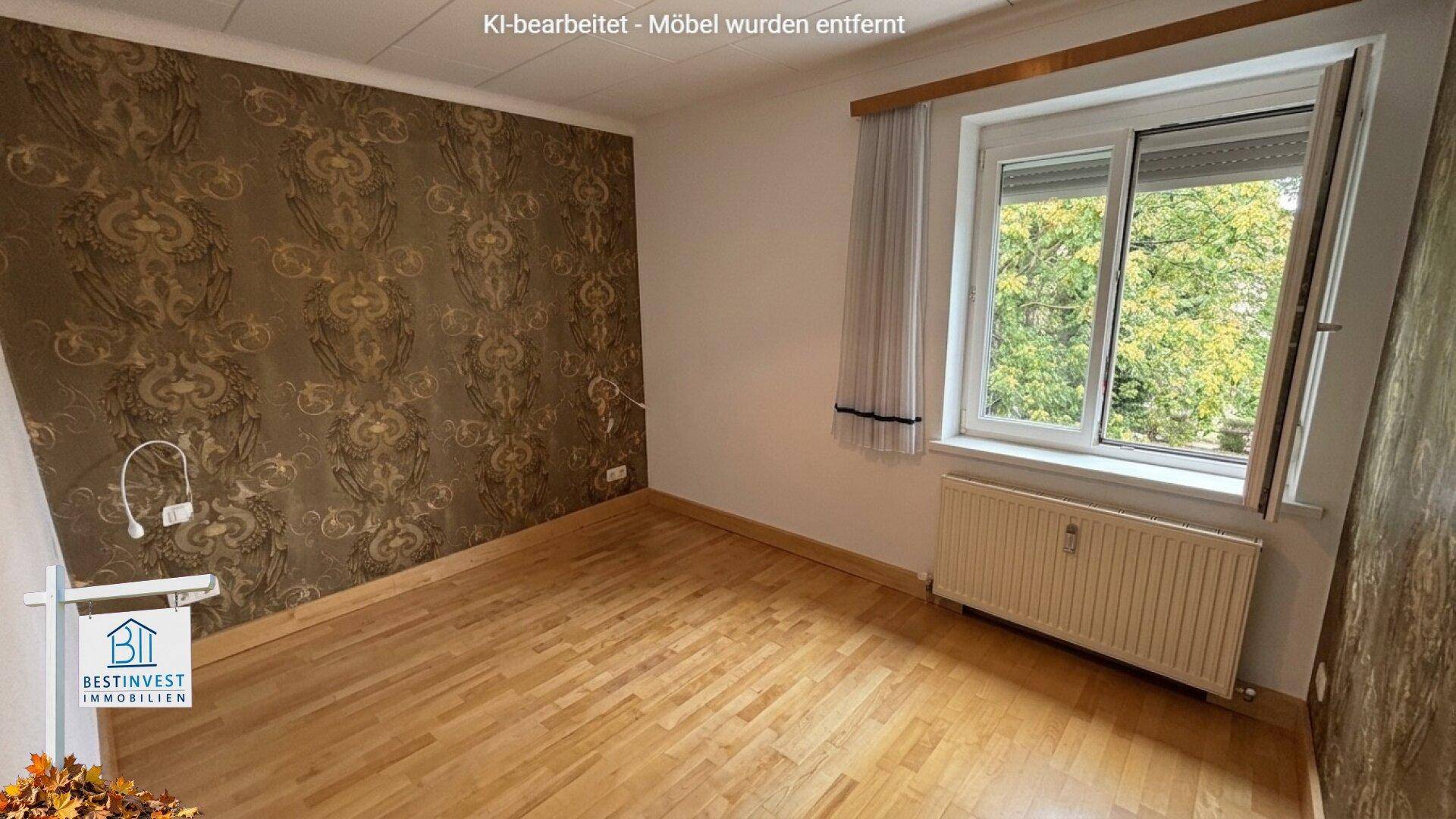 Leeres Schlafzimmer mit gemusterter Tapete und Parkettboden, bereit zur Neugestaltung.