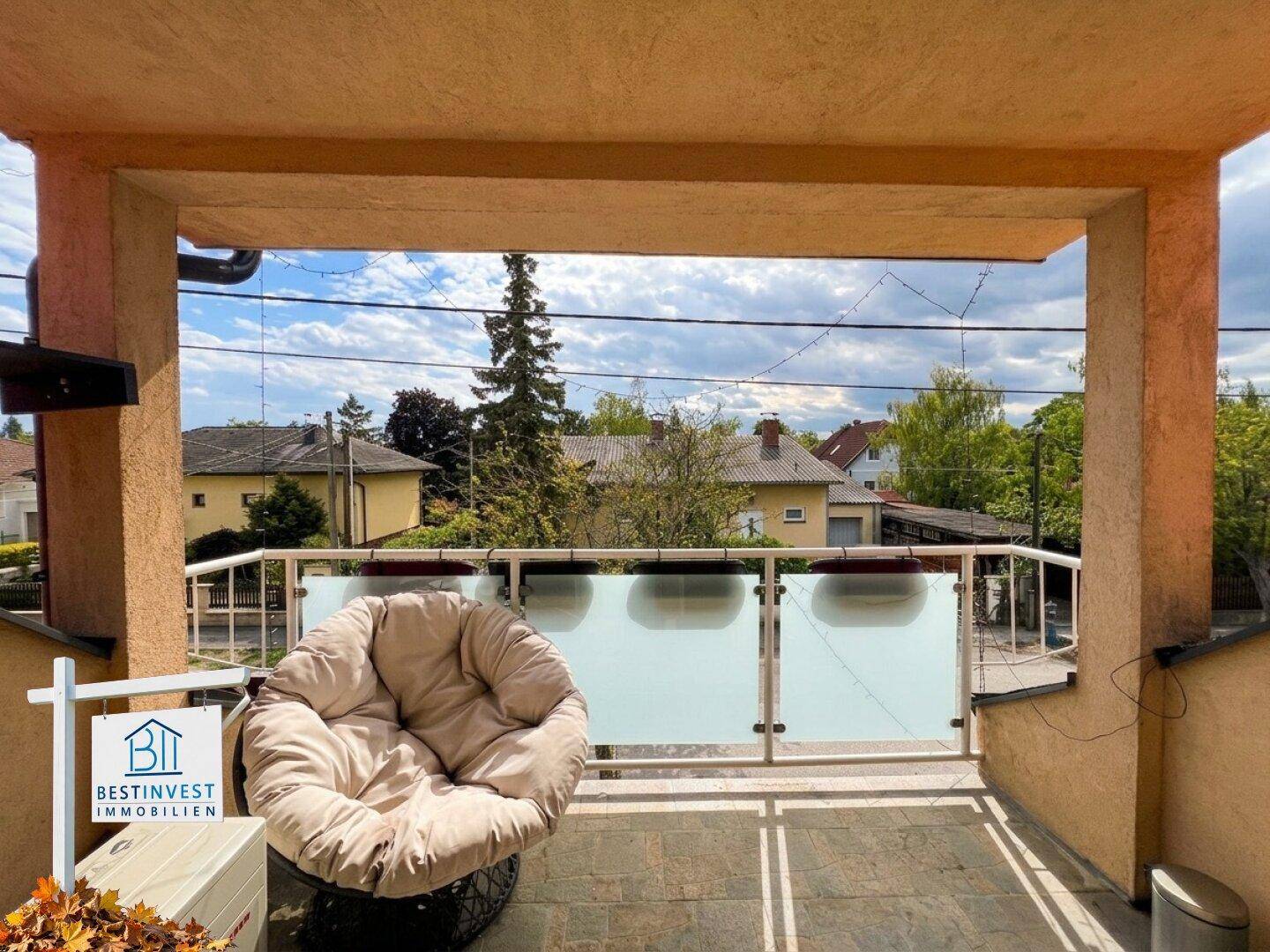 Überdachter Balkon mit Sitzgelegenheit und Blick auf die Umgebung, ideal für ruhige Stunden.