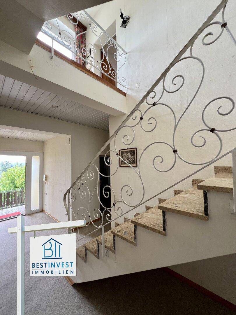 Elegante Treppe mit Marmorstufen und kunstvollem schmiedeeisernem Geländer.