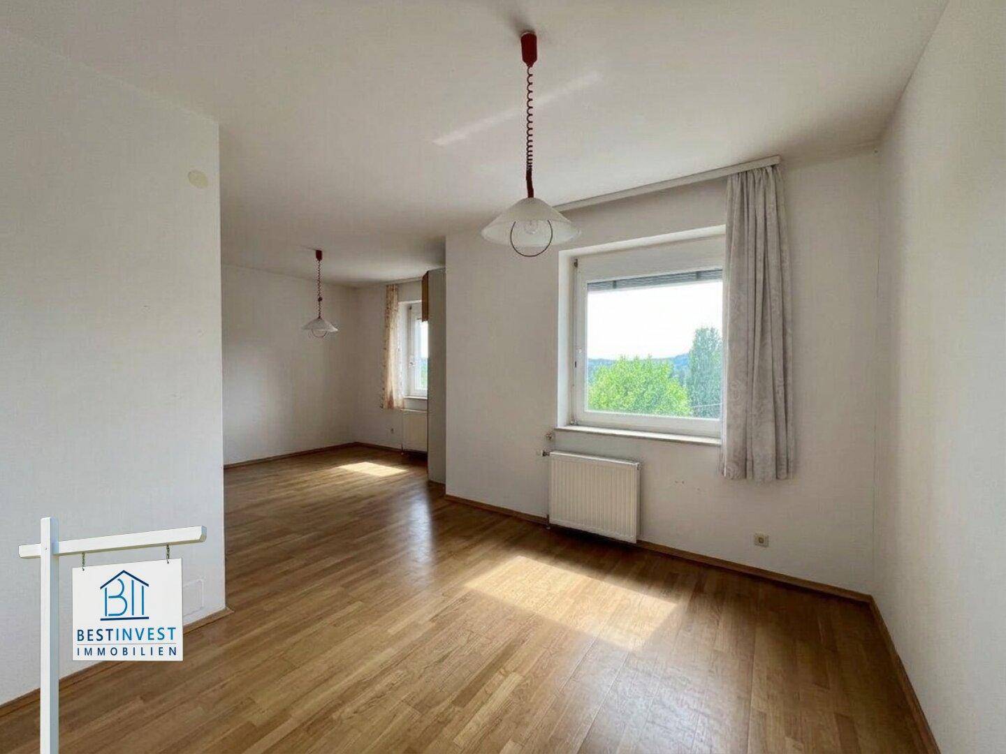 Helles Zimmer mit Parkettboden und Fenster, bietet einen angenehmen Ausblick.