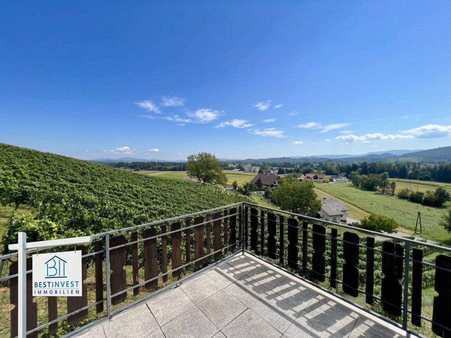 Terrasse mit Metallgeländer und beeindruckendem Blick auf die Weinberge und die weite Landschaft.