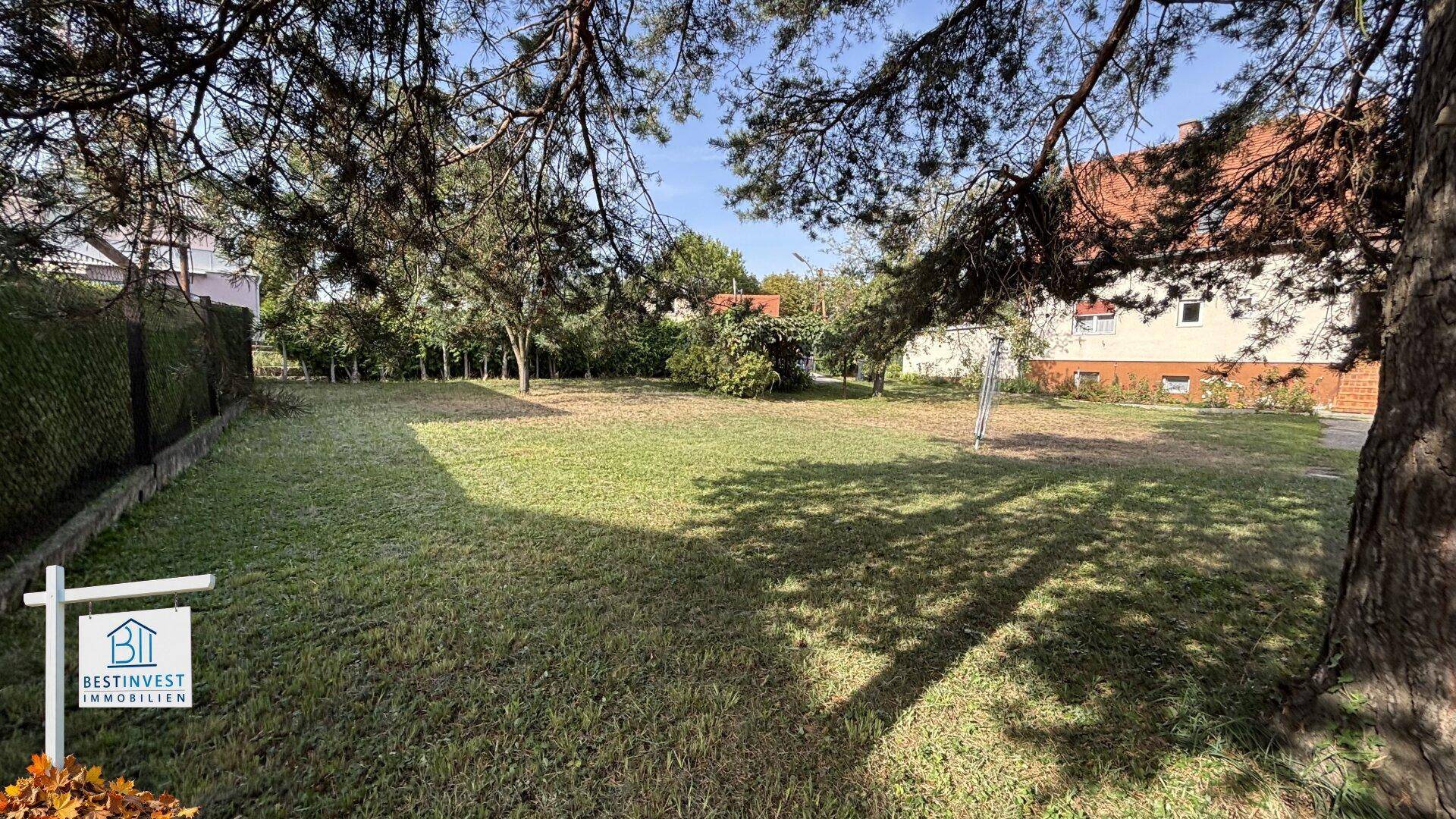 Weitläufige Rasenfläche mit vereinzelten Bäumen, ideal für Gartenliebhaber und Erholung.
