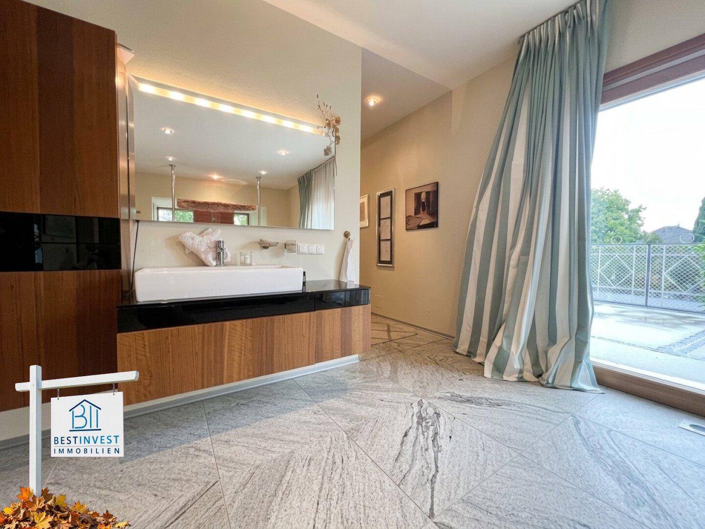 Modernes Badezimmer mit stilvollem Waschtisch und großen Fenstern mit Blick nach draußen.