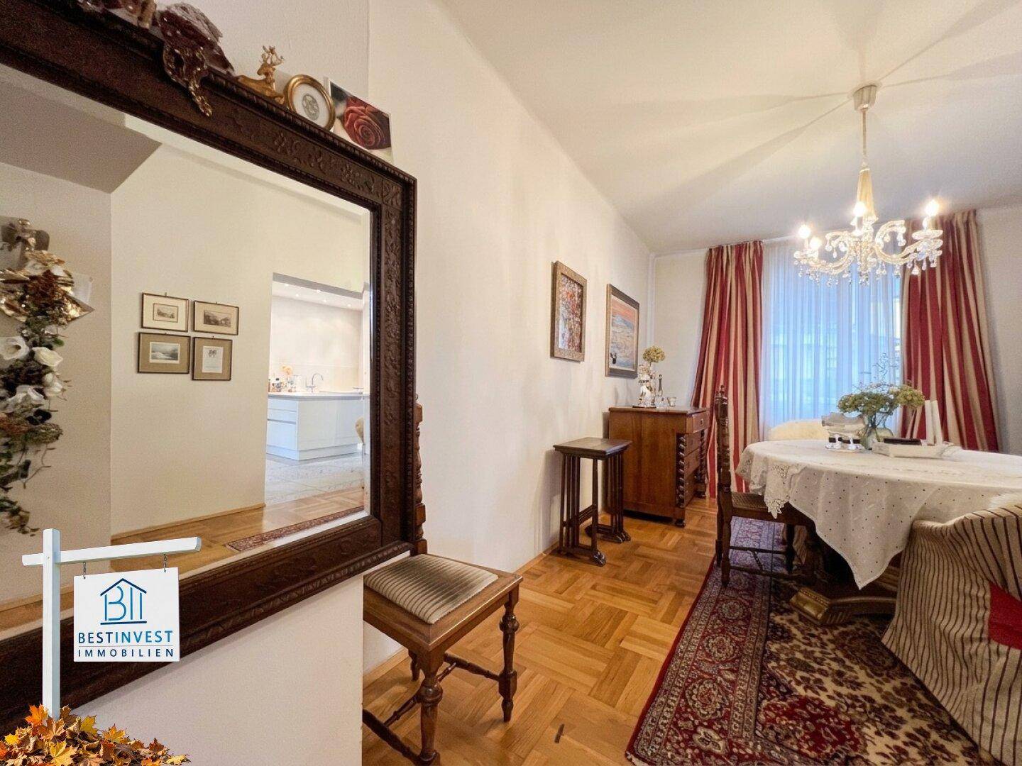 Elegantes Esszimmer mit traditionellen Möbeln, großem Spiegel und Fischgrätparkett.