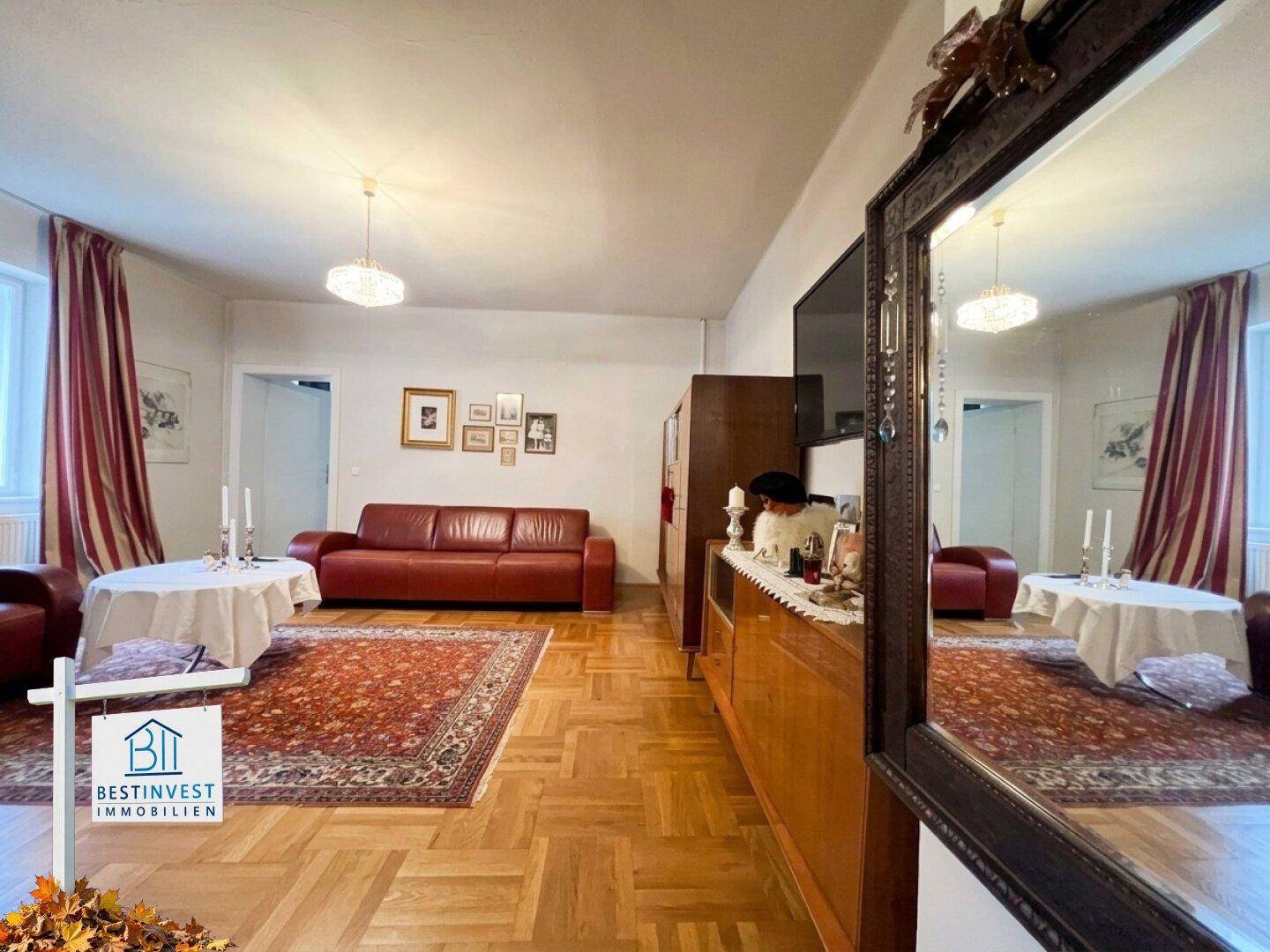 Helles Wohnzimmer mit rotem Sofa, großem Spiegel und offenem Grundriss.