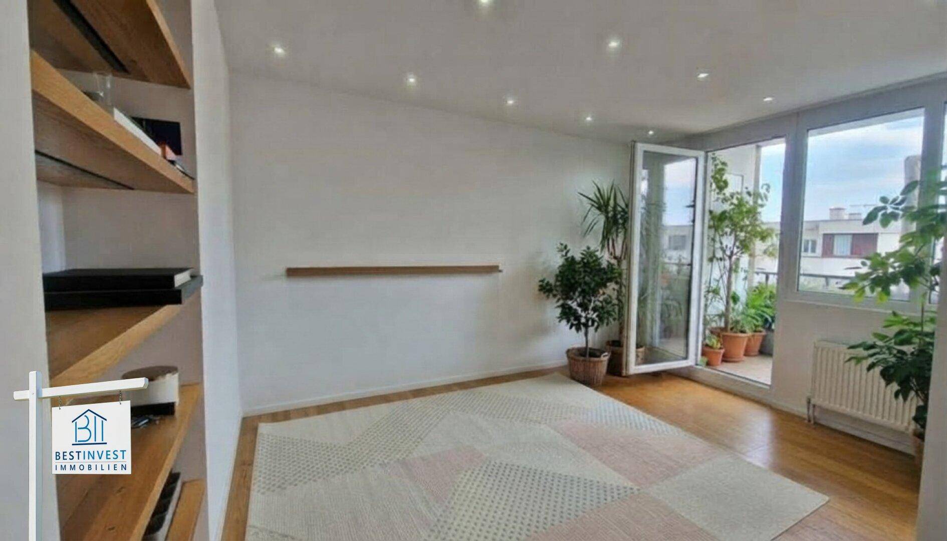 Geräumiges Wohnzimmer mit Holzboden, großen Fenstern und direktem Balkonzugang.