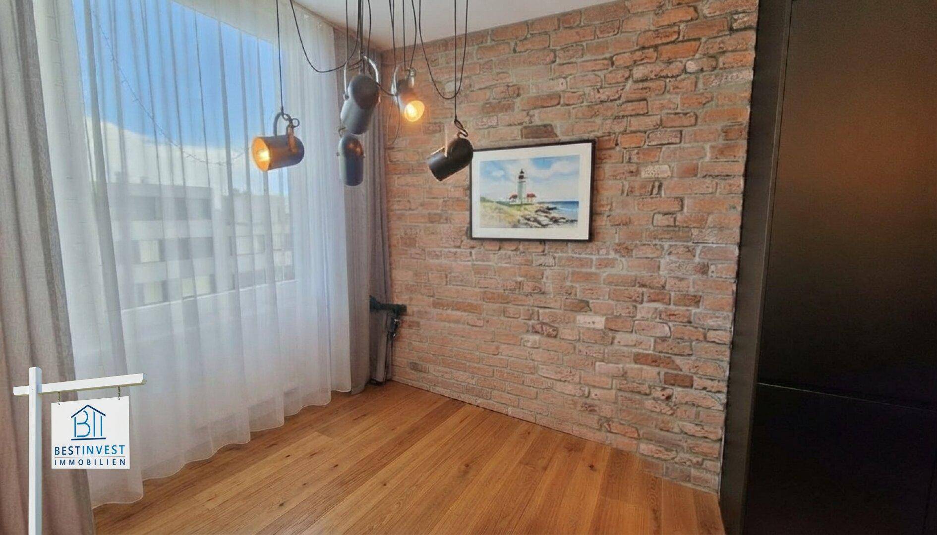 Raum mit freiliegender Ziegelwand, Holzboden und modernen Hängelampen im Industriedesign.