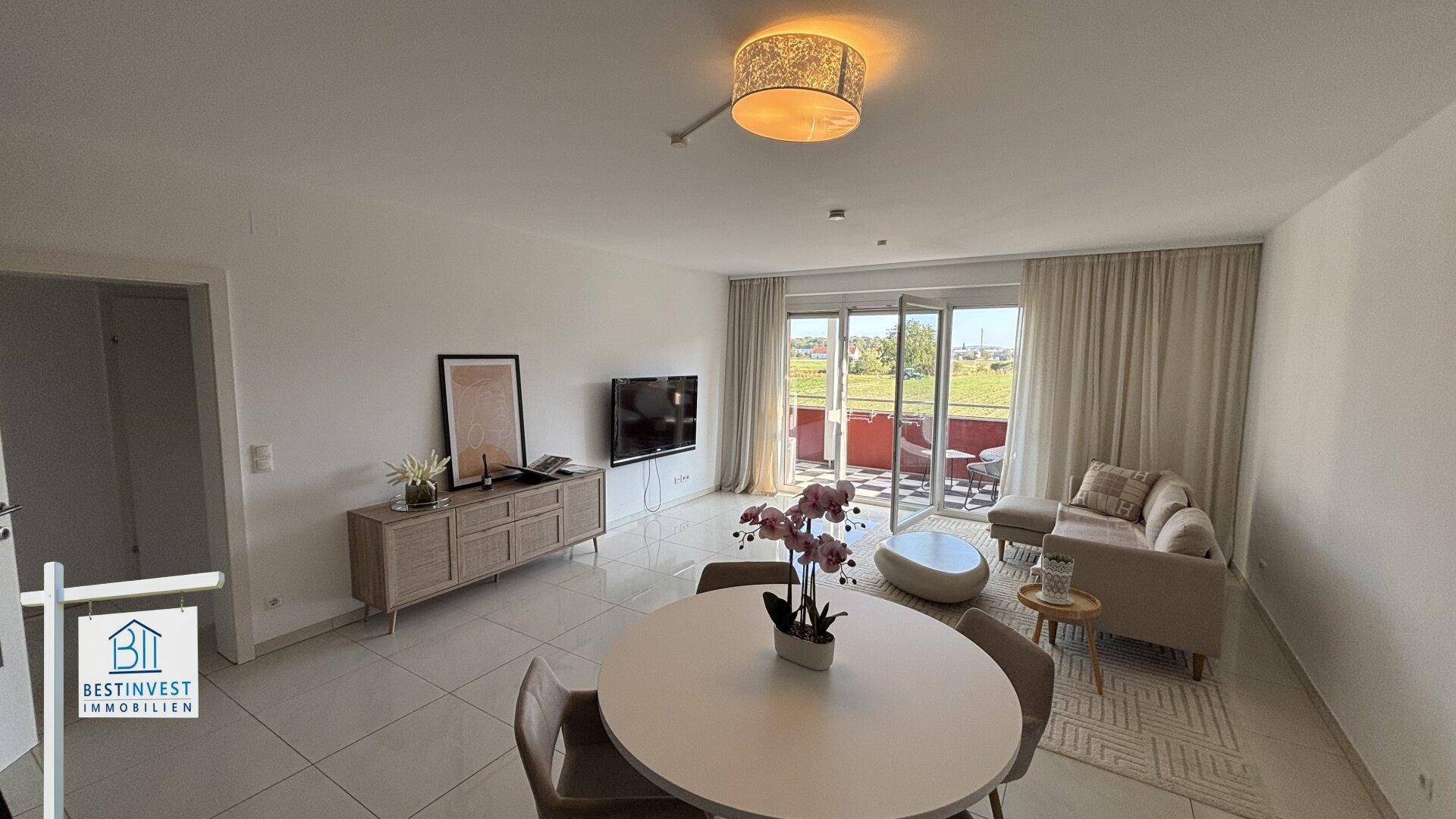 Heller Wohn- und Essbereich mit moderner Einrichtung und direktem Zugang zum Balkon.