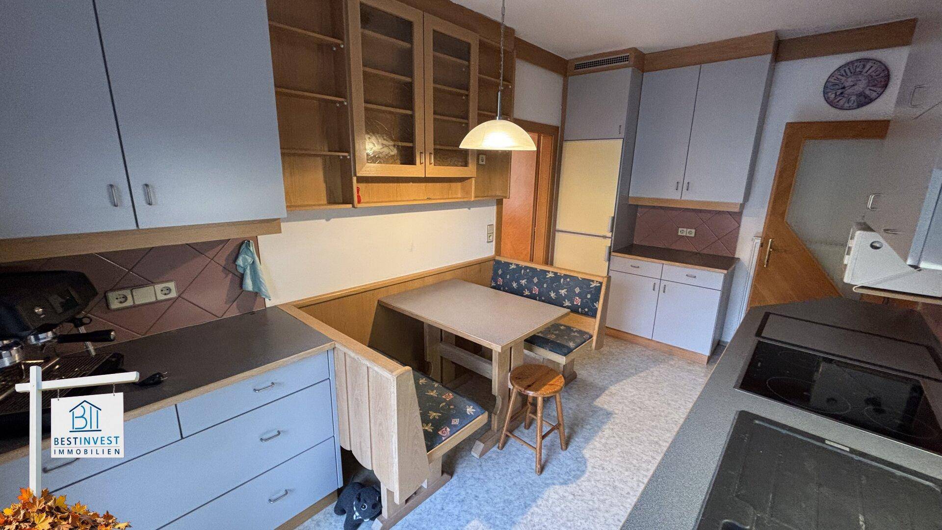 Geräumige Küche mit integriertem Essbereich, Holzschränken und viel Stauraum.