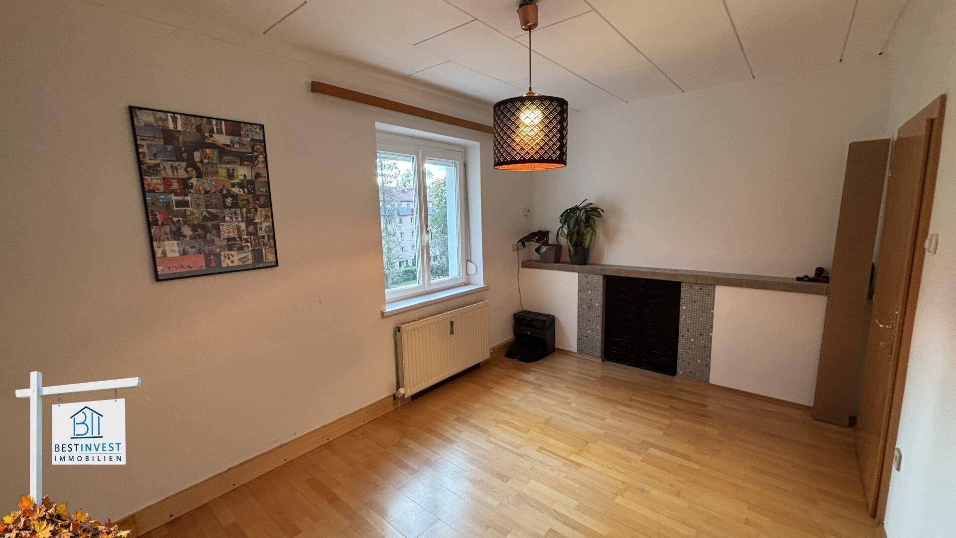 Leeres Zimmer mit Parkettboden und einer dekorativen Wandnische, ideal als Wohnzimmer.