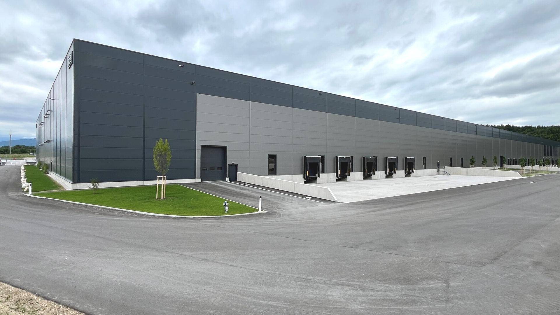 Panoramablick auf das weitläufige, moderne Logistikzentrum mit Laderampen und großzügigen Zufahrten.