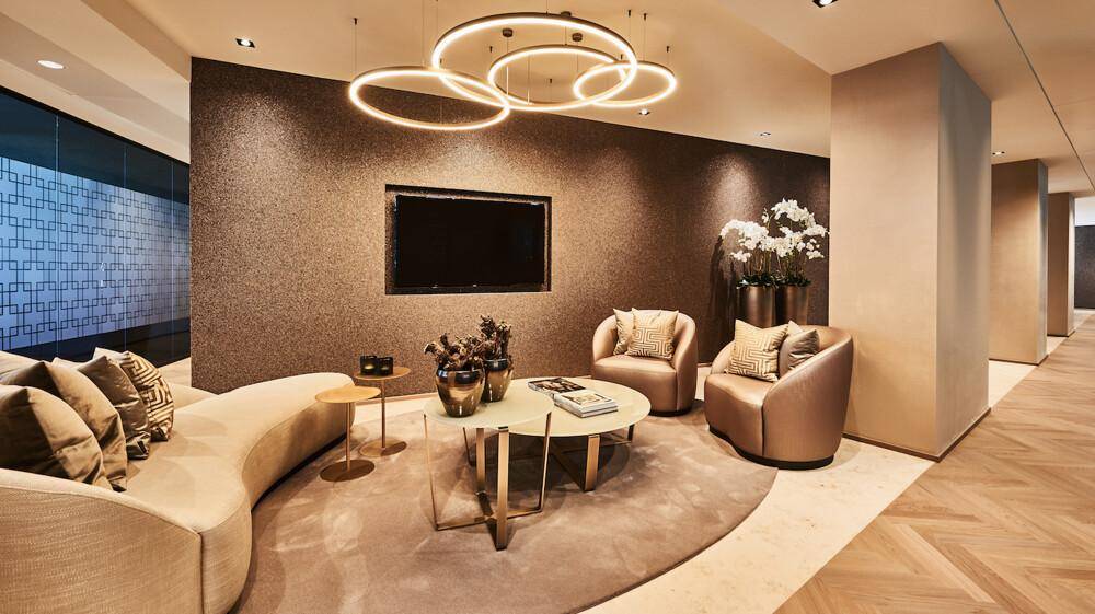 Gemütlicher Loungebereich mit bequemen Sofas, einem Couchtisch und einem großen Wandfernseher.