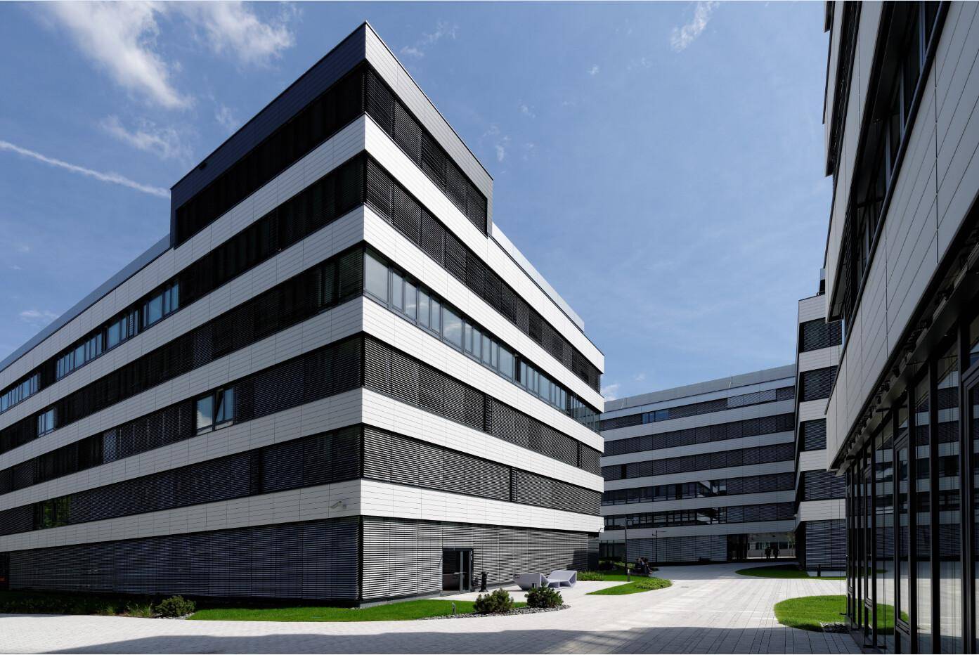 Zeitgenössisches Bürogebäude mit markanter schwarz-weißer Fassade und großen Fensterfronten.