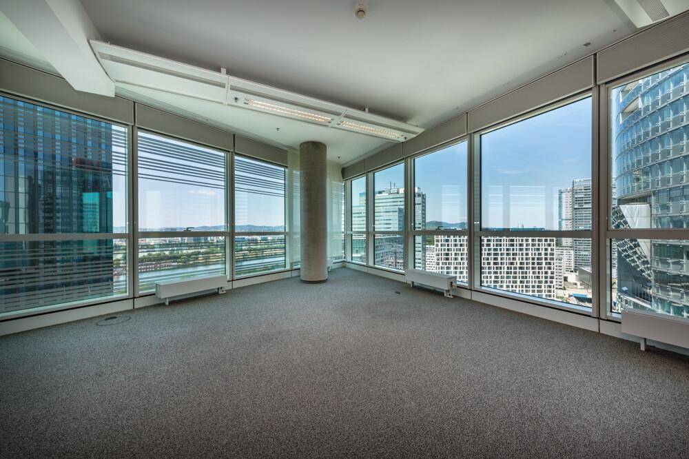 Geräumiger Büroraum mit großen Fenstern, die einen beeindruckenden Panoramablick auf die Stadt bieten.
