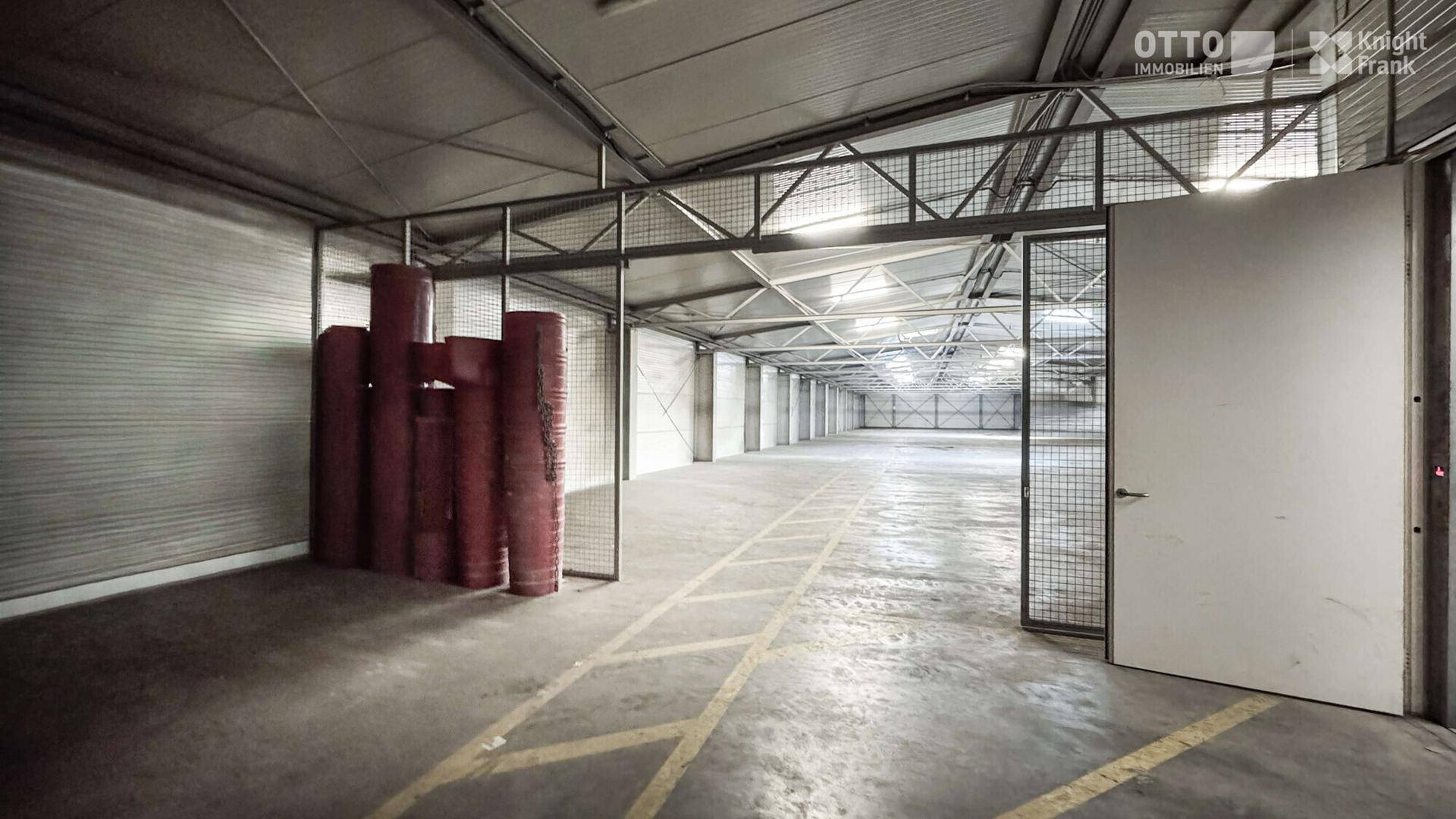 Große, leere Lagerhalle mit Betonboden und Metallkonstruktion, bereit für die Nutzung mit ausreichend Platz.