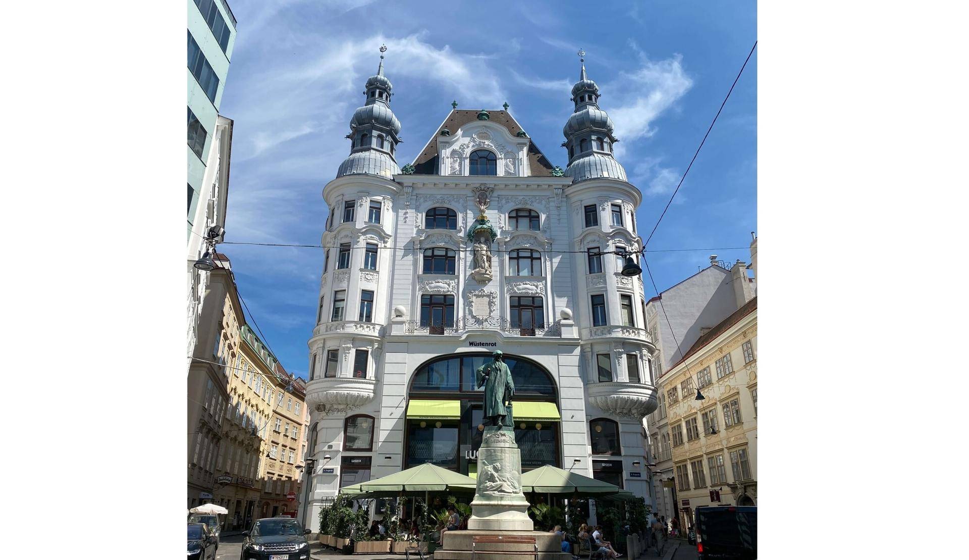 Prachtvolles historisches Gebäude mit zwei Türmen und aufwendiger Fassade in einer belebten Stadtansicht.