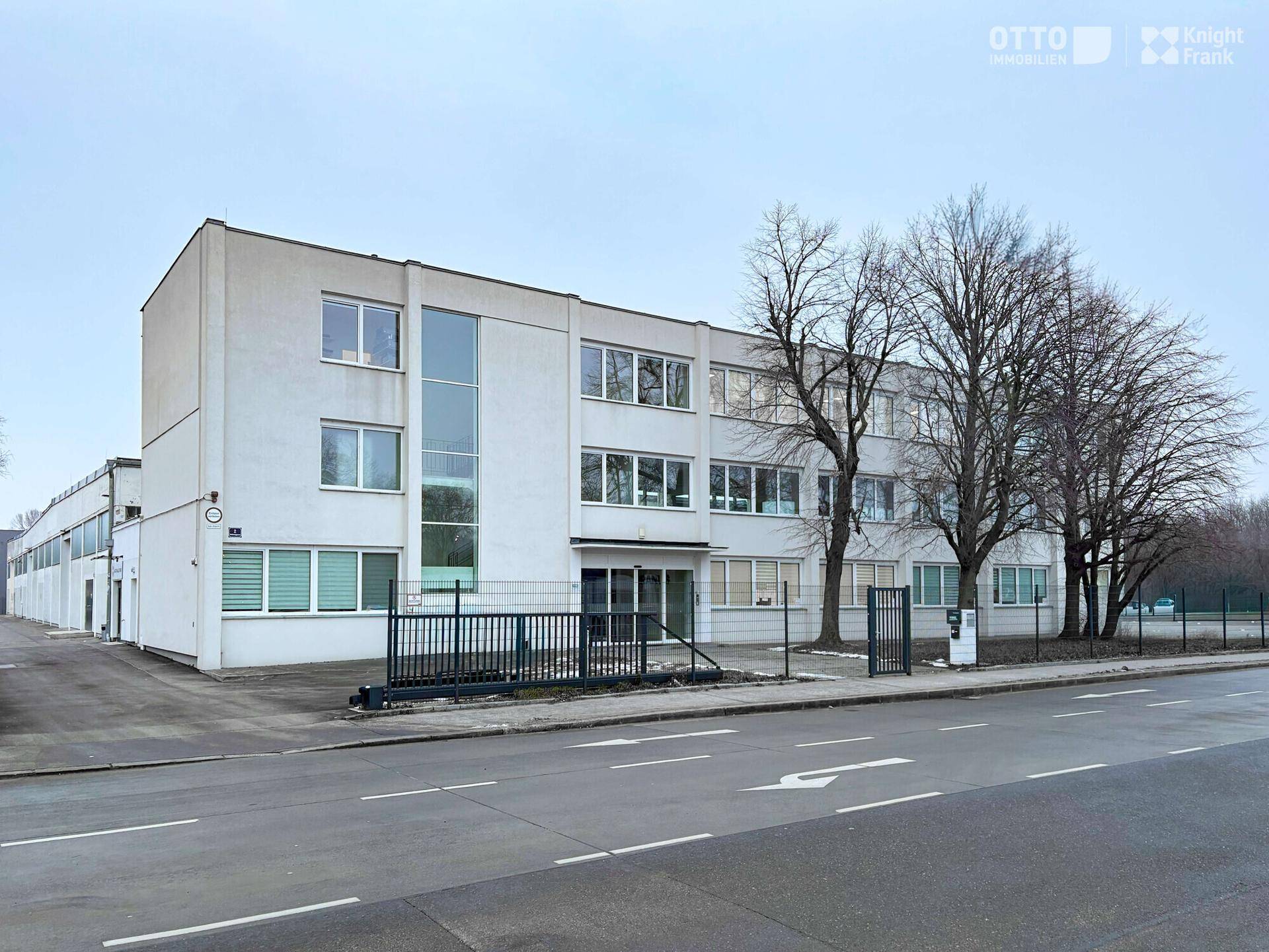 Außenansicht eines modernen Bürogebäudes mit mehreren Etagen und großen Fenstern an einer Straße.