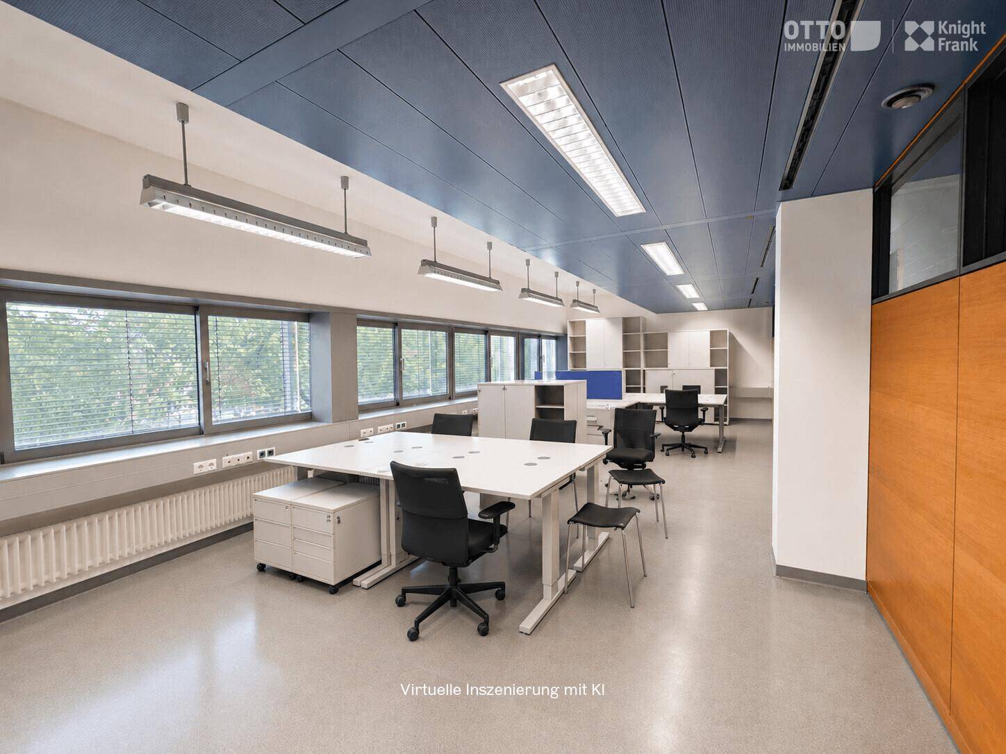 Modern eingerichtetes Büro mit mehreren Arbeitsplätzen, großen Fenstern und abgehängter Decke.