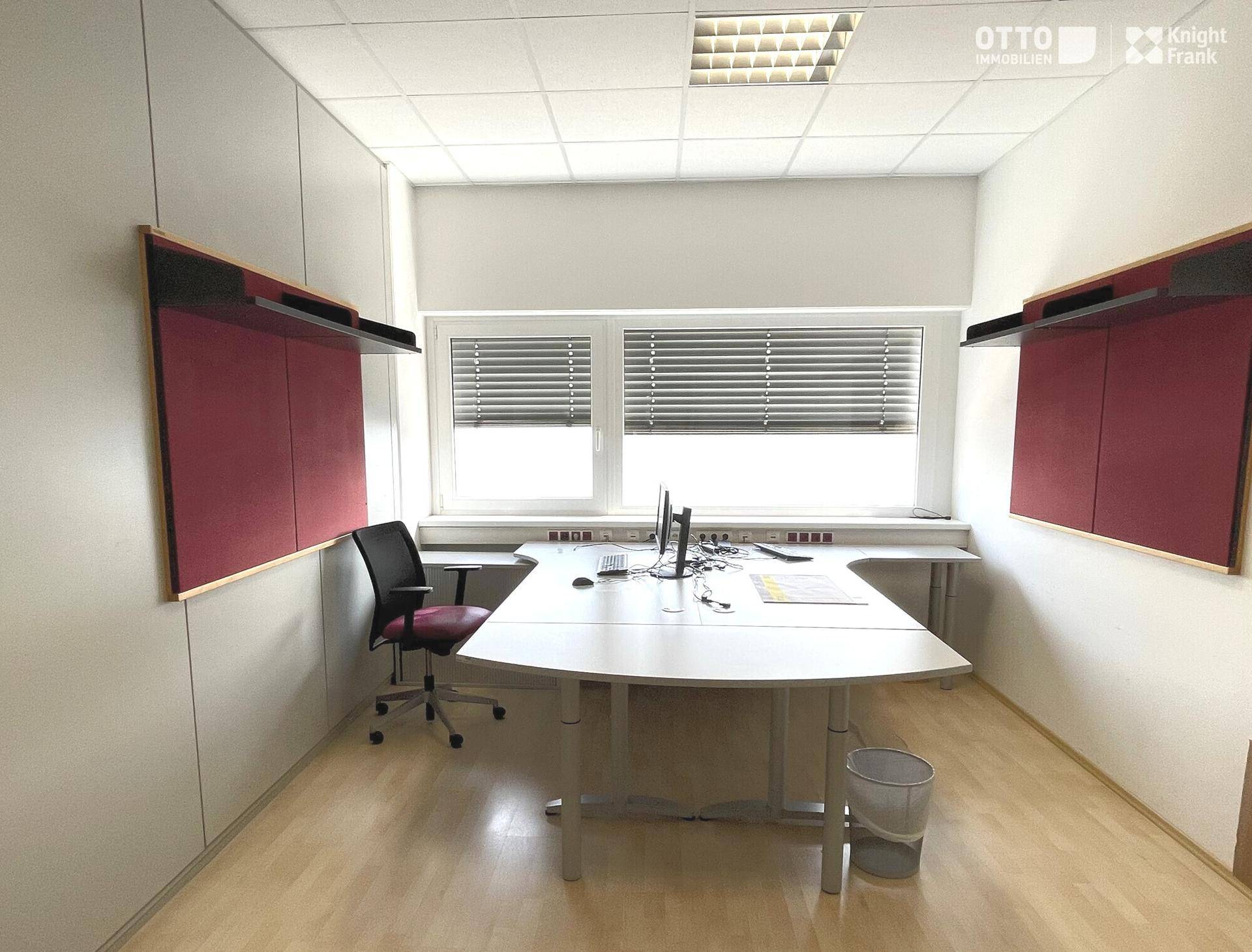 Helles Büro mit Holzfußboden, großem Fenster und modernem Schreibtisch, ideal für konzentriertes Arbeiten.