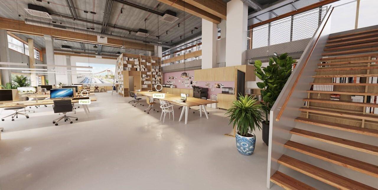 Großzügiges, modernes Büro mit offener Treppe, hohen Decken und verschiedenen Arbeitsbereichen, beleuchtet durch große Fenster.