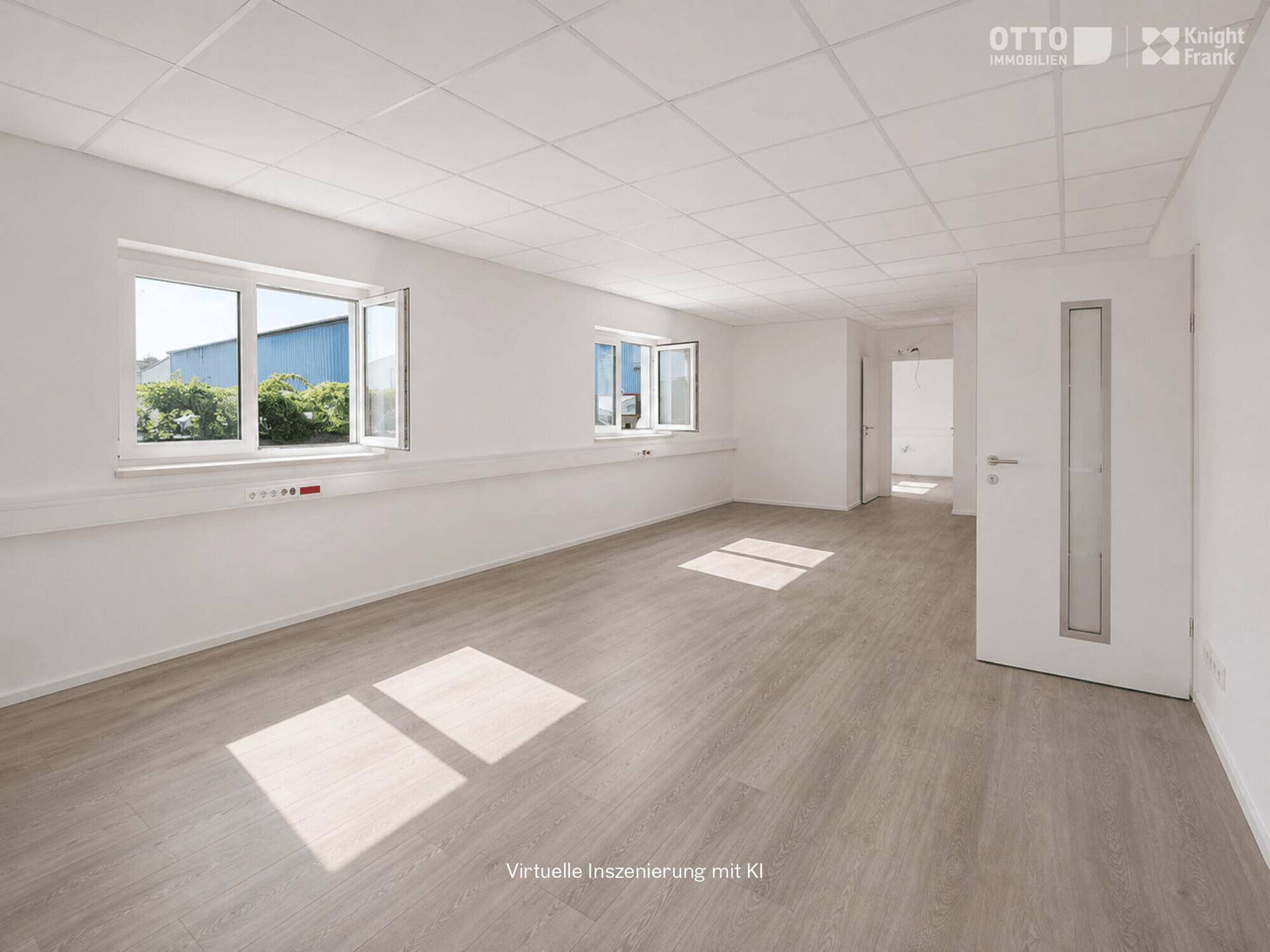 Helles und geräumiges Büro mit großen Fenstern, abgehängter Decke und modernem Laminatboden.
