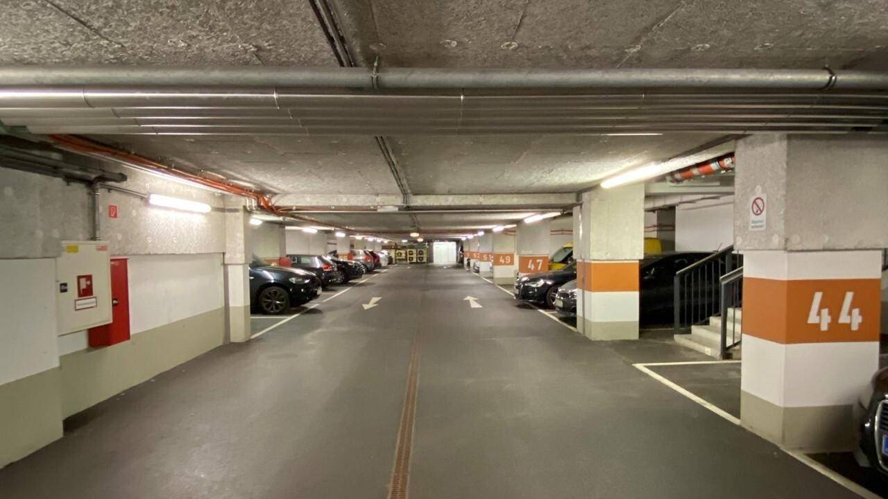 Tiefgarage mit vielen Parkplätzen, Betonstützen und guter Beleuchtung.