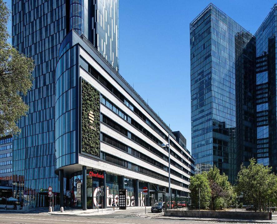 Moderne Bürogebäude mit Glasfassaden und vertikaler Begrünung an der Außenwand.