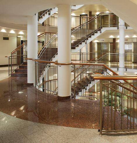 Elegante Lobby mit breiter Treppe, poliertem Granitboden und modernen Geländern.