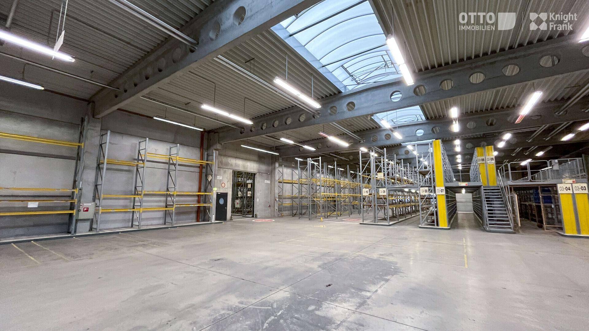 Lagerhalle mit hohen Regalsystemen, Betonboden und Oberlichtern, optimiert für Lagerung und Logistik.
