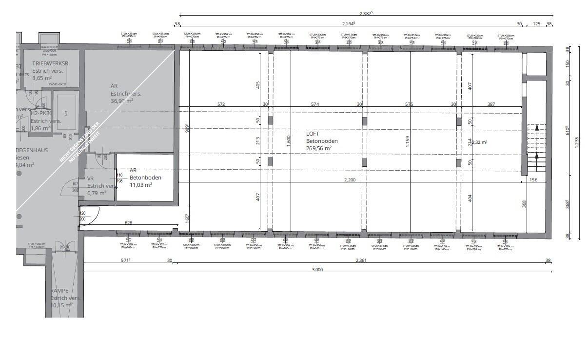 Detaillierter Grundriss eines großen Loftbereichs mit Betonboden, Säulen und angrenzenden Räumen.