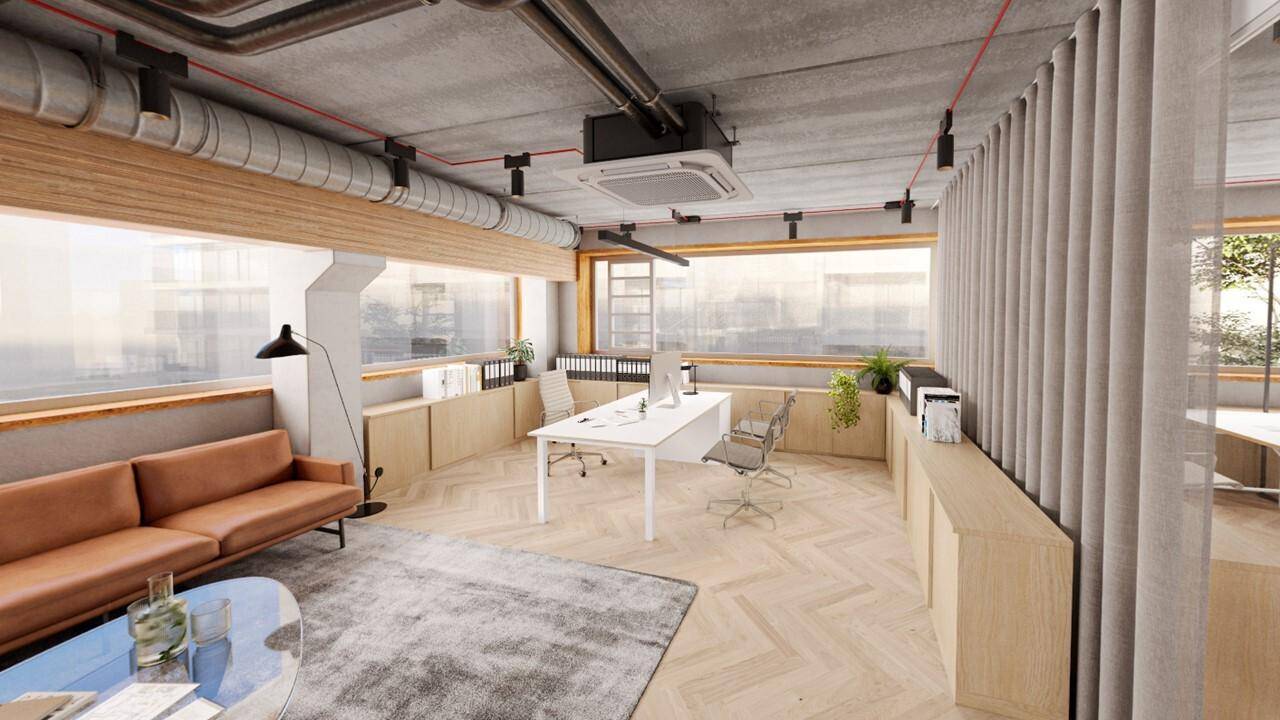 Modernes Büro mit bequemer Ledercouch, Teppich und Arbeitsplätzen, umgeben von großen Fenstern und Holzelementen.