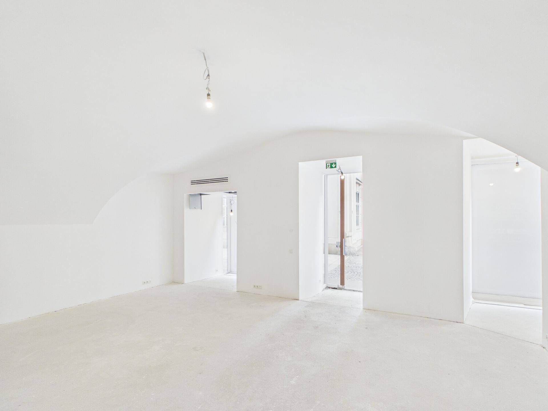 Weitläufiger Gewerberaum mit Gewölbedecken und Blick auf den Eingang, der viel Tageslicht hereinlässt.