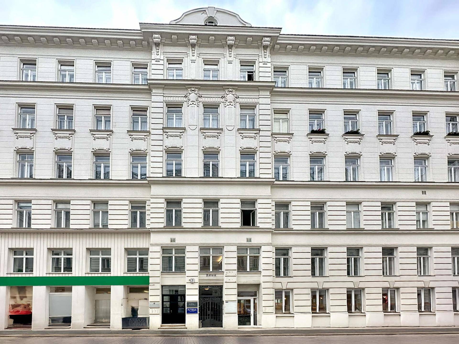 Klassische Altbaufassade mit vielen Fenstern und dekorativen Elementen in der Stadt.