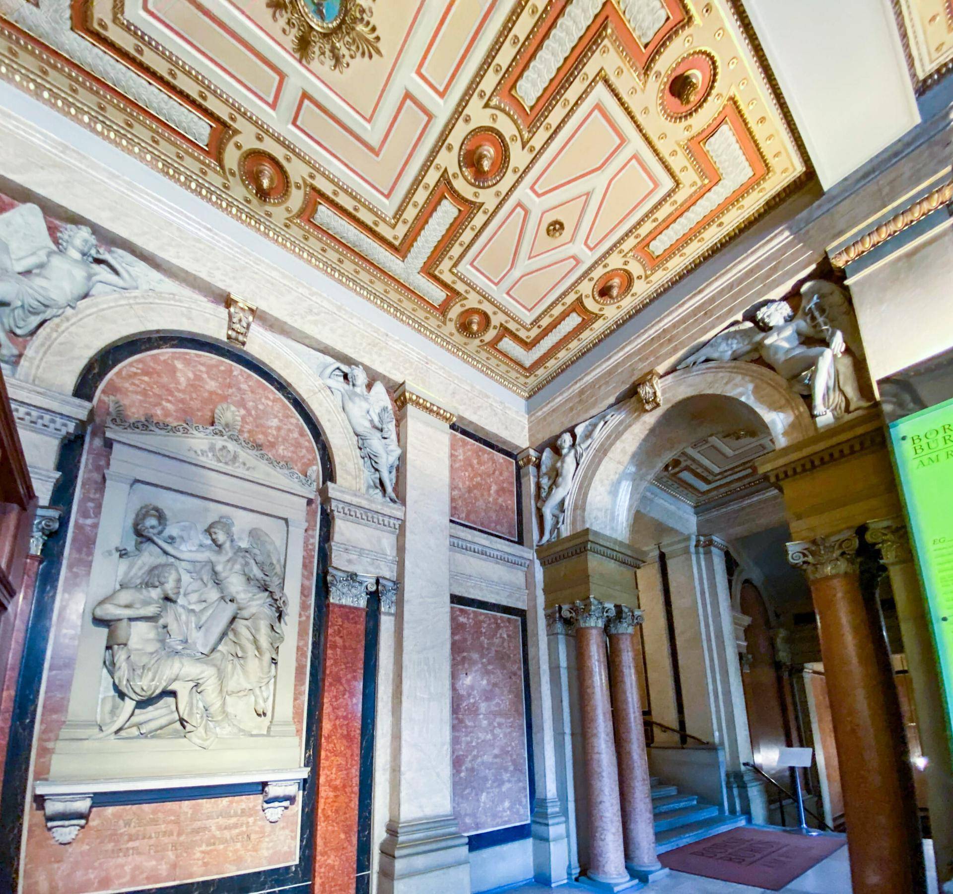 Prunkvoller Eingangsbereich mit Marmorverkleidung, Skulpturen und aufwendig gestalteter Decke.