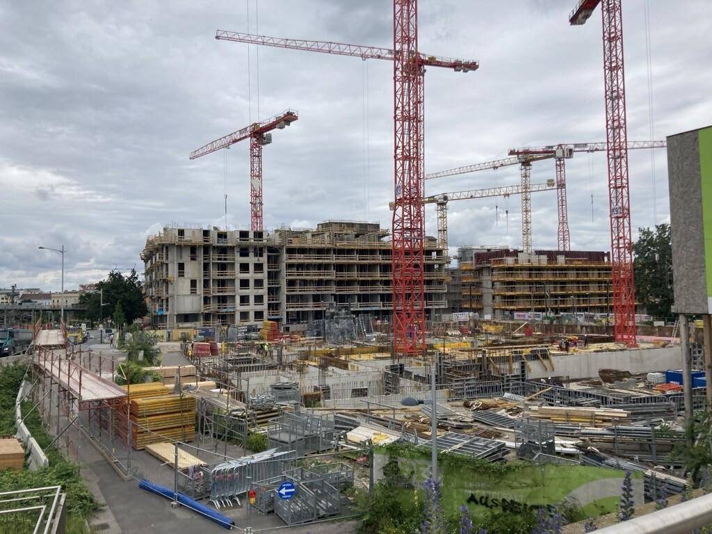 Baustellenansicht eines im Bau befindlichen Gebäudes mit Gerüsten und Kränen, bereit für den weiteren Ausbau.