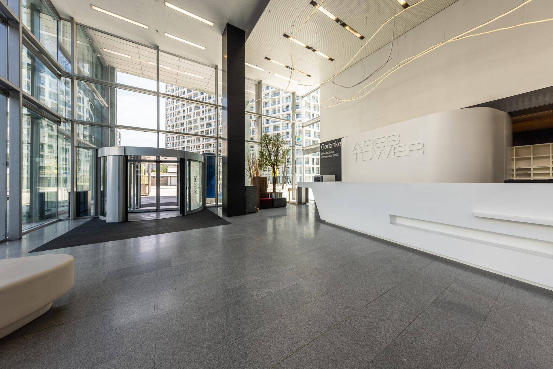 Weitläufige, helle Lobby mit großflächiger Verglasung und modernem Empfangsbereich.