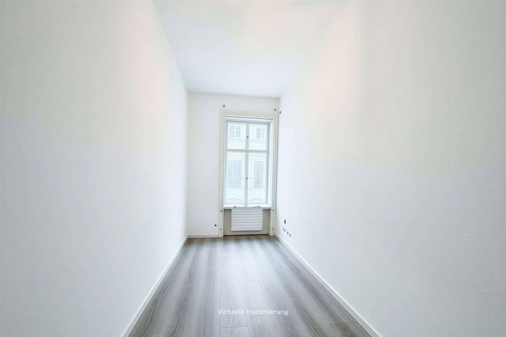 Schmaler, heller Raum mit einem hohen Fenster und grauem Laminatboden, ideal für ein kleines Büro.